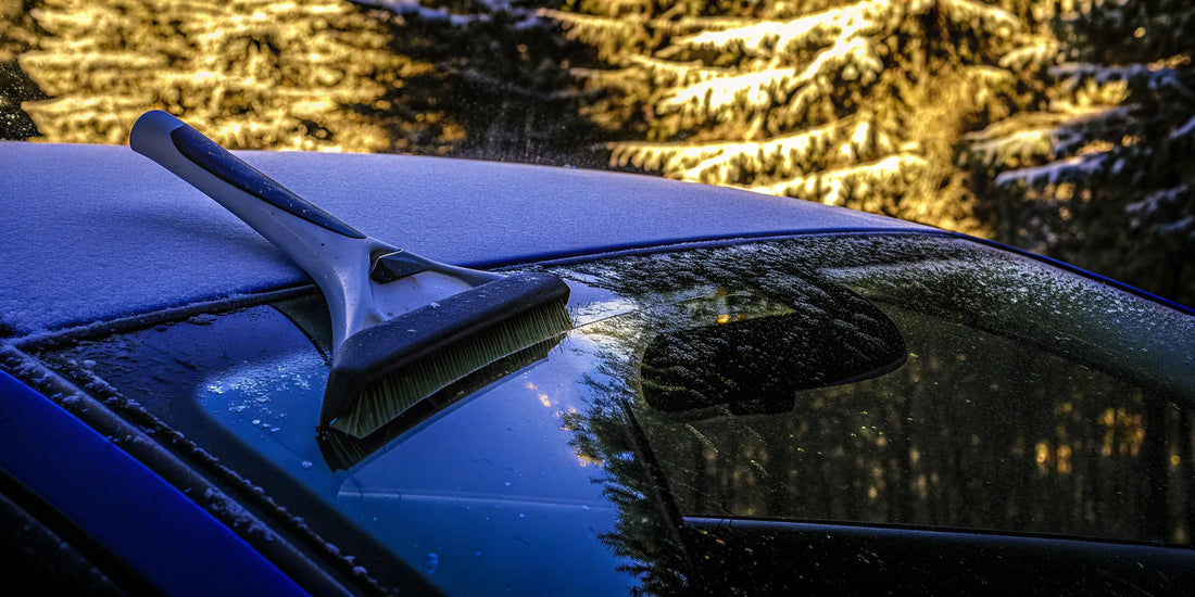 An effective snow scraper clearing a car windshield covered in heavy snow.