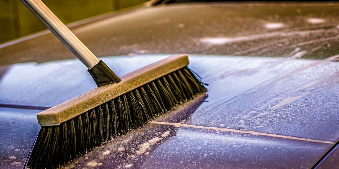 A snow brush's stiff bristles scratching a car's paint.