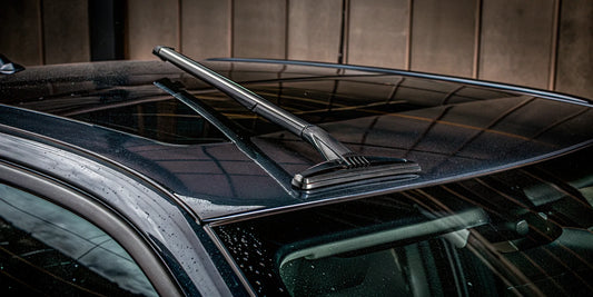 A quality snow and ice scraper on a snowy car, ready for winter weather.
