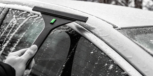 Bulk vehicle-safe snow scraper clearing a fleet vehicle's window for improved winter safety.