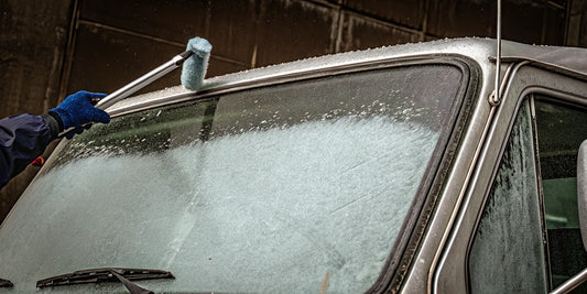 How to remove ice from a large truck windshield using a long-handled scraper.