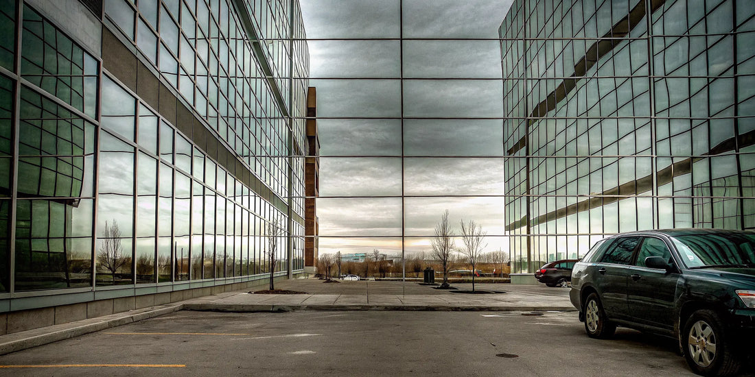 A person uses a snow brush to safely remove snow from the roof of a car.