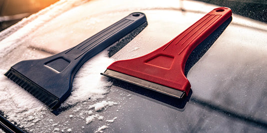 A silicone vs plastic car ice scraper clearing an icy windshield.