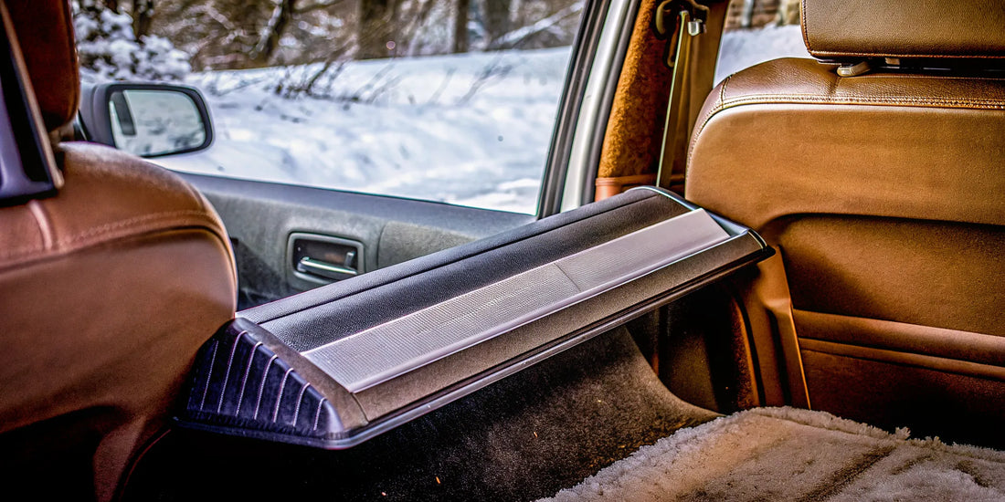 The Edge ice scraper stored flat on a car backseat showing its space-saving rectangular design