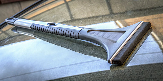 A durable, personalized ice scraper with a brand logo clearing a car's icy windshield.