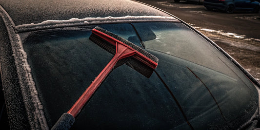 Promotional products snow scraper beside a frosted vehicle