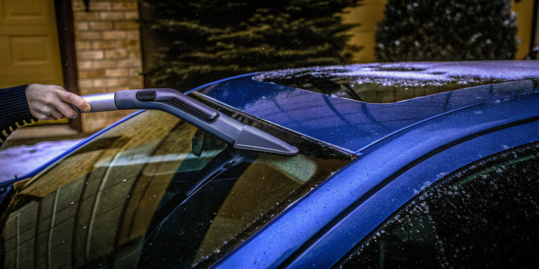 Clearing ice from a frozen wiper blade with a specialized cleaner tool.