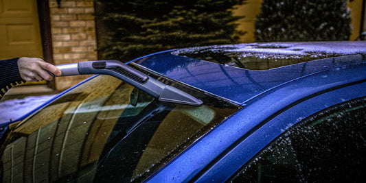 Clearing ice from a frozen wiper blade with a specialized cleaner tool.