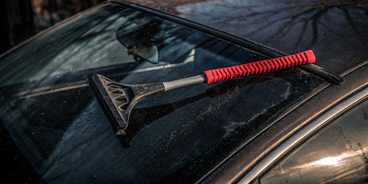 The Edge super-sized ice scraper next to a traditional plastic scraper on a frozen windshield, side by side comparison
