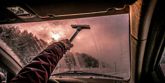 Driver clearing frost from a tall pickup truck windshield with The Edge wide ice scraper
