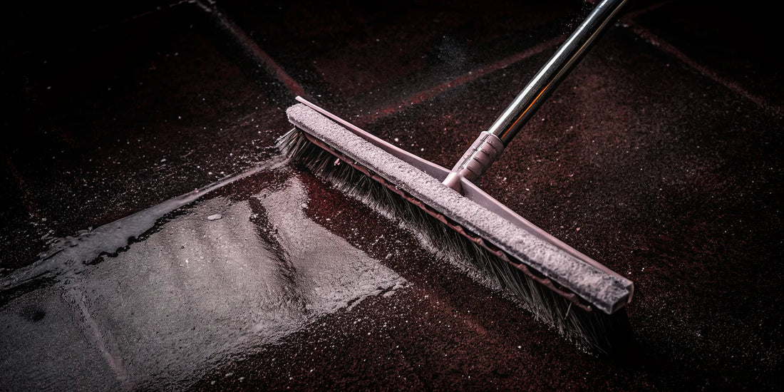 The Edge snow and ice removal tool shattering ice on a car windshield with its pain-free ergonomic grip.