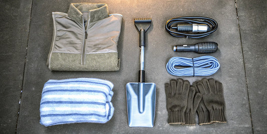 A complete winter vehicle emergency kit with tools like a shovel and jumper cables for roadside safety.
