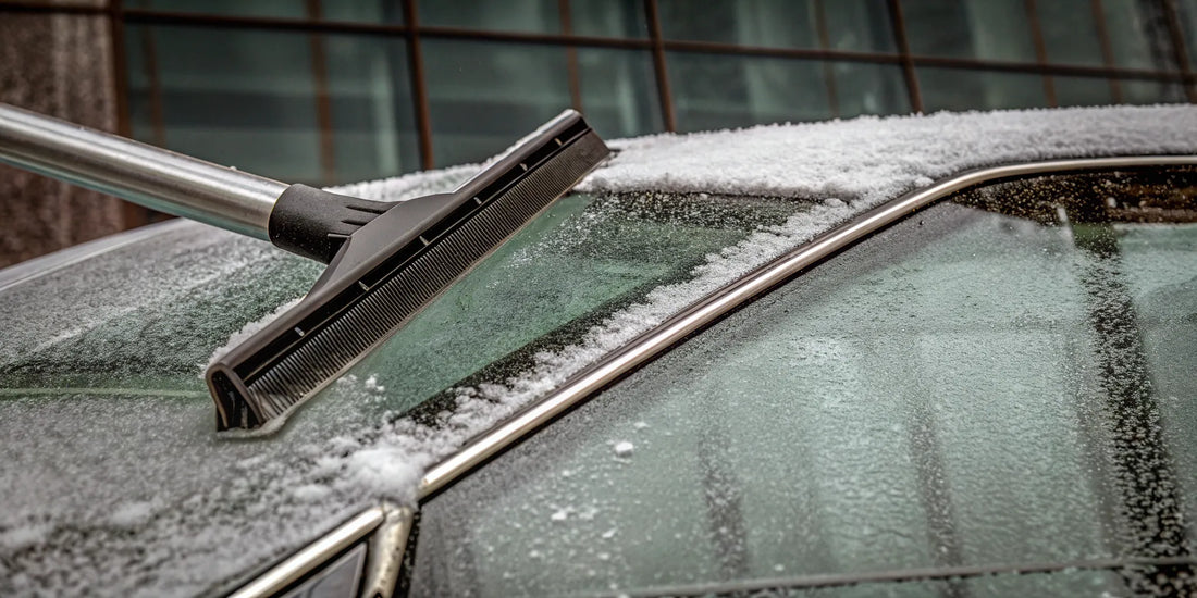 Heavy duty snow scraper removing thick ice from a car windshield.