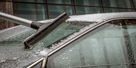 Heavy duty snow scraper removing thick ice from a car windshield.