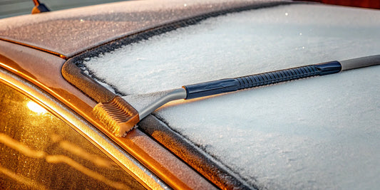 An ice scraper on a frosted car windshield, an essential winter car accessory.