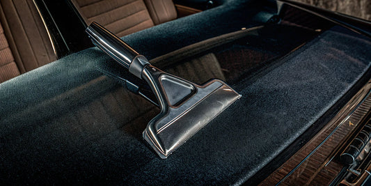 A waterproof mitt ice scraper clearing thick ice from a car windshield.