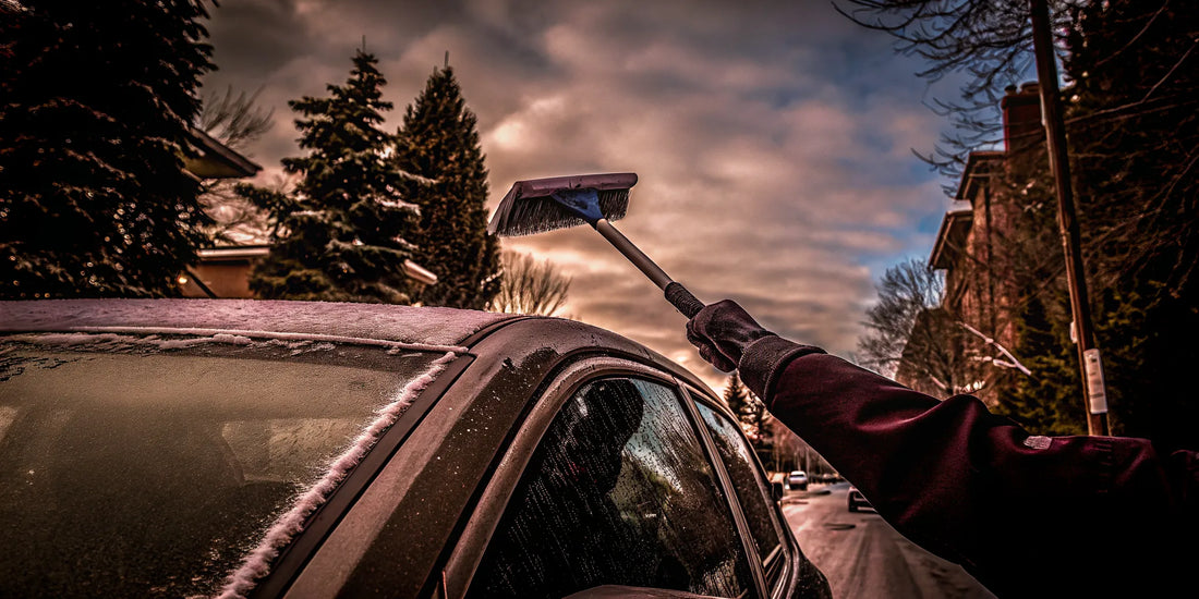 Driver clearing an icy windshield with a durable scraper