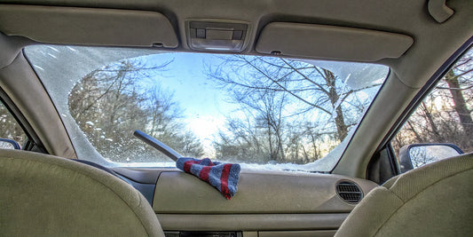 Winter car safety preparation with ice scraper and emergency kit on car seat