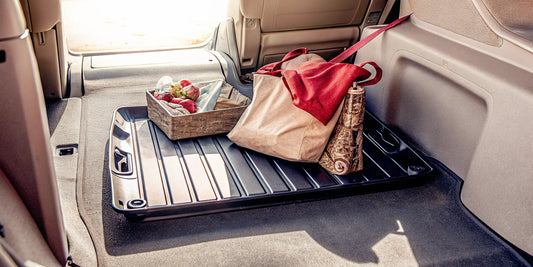 The Edge snow and ice scraper laid flat on car trunk floor as multi-purpose tray for year-round use